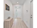 Bright entryway with wood-look flooring, modern decor, and a view of the front door at 4484 Lions Gate Ave, Clermont, FL 34711