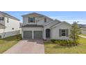 Charming two-story home with gray shutters, a brick driveway, and manicured landscaping at 4484 Lions Gate Ave, Clermont, FL 34711