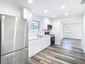 Open kitchen features stainless steel appliances, white cabinets, and hardwood floors at 4502 Florence St, Apopka, FL 32712