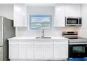Bright kitchen with stainless steel appliances, white cabinets and a window over the sink at 4502 Florence St, Apopka, FL 32712