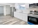Modern kitchen featuring stainless steel appliances, white cabinetry, and sleek countertops at 4502 Florence St, Apopka, FL 32712