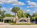Reunion Resort entrance featuring lush landscaping and clear blue skies, with a palm tree at 7691 Heritage Crossing Way # C-1, Reunion, FL 34747