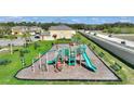 Community playground with swings, slides, and green space with picnic tables for Gathering enjoyment at 824 Washington Palm Loop, Davenport, FL 33897