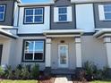 Attractive townhome exterior with a covered entrance, lush landscaping, and charming architectural details at 9338 Bolshoi Aly, Winter Garden, FL 34787
