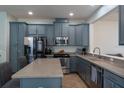 Modern kitchen with stainless steel appliances, a spacious island, and gray cabinets at 9575 Silver Buttonwood St, Orlando, FL 32832