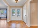 Welcoming foyer featuring elegant double doors with glass inserts and beautiful hardwood flooring at 980 Oleander Se Dr, Winter Haven, FL 33880