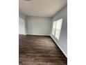 Bright, airy living room with wood-look flooring, light gray walls, and natural light from a large window at 1117 Cambourne Dr, Kissimmee, FL 34758