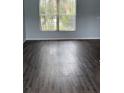 Spacious room featuring wood-look flooring, light gray walls, and a window for natural light at 1117 Cambourne Dr, Kissimmee, FL 34758