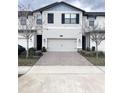 Charming two-story townhome with a two-car garage and brick-paved driveway at 11588 Whistling Pine Way, Orlando, FL 32832