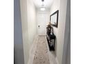 Bright hallway featuring neutral walls, tile floors, and stylish console table at 11588 Whistling Pine Way, Orlando, FL 32832
