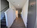 Inviting hallway with wood floors, leading to the main living area and staircase at 1209 S Station Pl # 306, Orlando, FL 32827