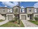 Exterior view of townhome featuring neutral paint, one car garage, and small lawn at 1217 S Station Pl # 502, Orlando, FL 32809