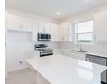 Modern kitchen featuring white cabinets, stainless steel appliances, and sleek countertops at 1329 Stockwell Ave, St Cloud, FL 34771