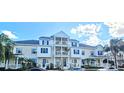 Townhomes with blue shutters, tiered balconies, manicured lawns, and palm trees at 136 Mcleods Way, Winter Springs, FL 32708