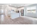 Open-concept kitchen with white cabinets, stainless steel appliances, and a center island at 14218 Lanikai Beach Dr, Orlando, FL 32827