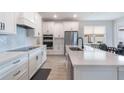 Modern kitchen with white cabinets, stainless steel appliances, and quartz countertops at 14218 Lanikai Beach Dr, Orlando, FL 32827