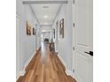 Inviting hallway with hardwood floors, recessed lighting, and decorative wall art leading to an open floor plan at 15245 Blue Peacock Ln, Winter Garden, FL 34787