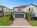 Charming two-story home boasts a well-manicured lawn, brick driveway, and inviting curb appeal in a desirable neighborhood at 2052 Milkweed St, Ocoee, FL 34761