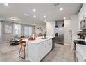 Bright, open-concept kitchen features a spacious island, stainless steel appliances, and seamless flow into the living area at 2052 Milkweed St, Ocoee, FL 34761