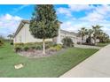 Well-maintained front yard with a neatly trimmed lawn, mature tree, and manicured landscaping showcasing the property's curb appeal at 2282 Kaley Ridge Rd, Clermont, FL 34715