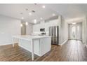 Bright kitchen with stainless steel appliances, center island, pendant lights, and wood-look tile flooring at 2282 Kaley Ridge Rd, Clermont, FL 34715