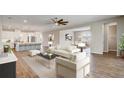 Bright living room open to a modern kitchen and dining area, with neutral decor and wood-look flooring at 2282 Kaley Ridge Rd, Clermont, FL 34715
