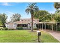 Inviting home with a mature palm tree and a covered carport adding to the property's appeal at 26 Backspin Ln, Orlando, FL 32804