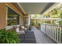 Relaxing covered porch featuring brick flooring, comfortable seating, and a tranquil outdoor view at 26 Backspin Ln, Orlando, FL 32804
