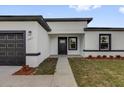 Charming single-story home showcasing a modern design with a gray garage door and fresh landscaping at 2640 Sw 156Th Lane Rd, Ocala, FL 34473