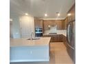 Modern kitchen with stainless steel appliances, a kitchen island, and wooden cabinets at 2765 Redblush Ter, St Cloud, FL 34772