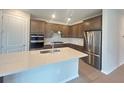 Modern kitchen with stainless steel appliances, a kitchen island, and wooden cabinets at 2765 Redblush Ter, St Cloud, FL 34772