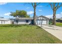 Inviting single-story home with a spacious front yard and attached two-car garage, perfect for a Gathering at 2801 W Covington Dr, Deltona, FL 32738