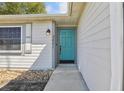 Close-up of a charming front door with a teal finish, complemented by white siding and a decorative light fixture at 2801 W Covington Dr, Deltona, FL 32738