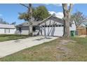 View of the home with an attached garage, mature trees, and driveway, showing a well-kept exterior at 2801 W Covington Dr, Deltona, FL 32738