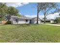 Exterior view of a cozy home featuring a well-manicured lawn, mature trees, and driveway at 2801 W Covington Dr, Deltona, FL 32738