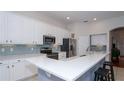 Modern kitchen featuring white cabinets, stainless steel appliances, and quartz countertops at 4527 Sunset Ln, Oviedo, FL 32765