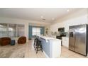 Open-concept kitchen with white cabinets, stainless steel appliances, quartz countertops, and a breakfast bar at 4527 Sunset Ln, Oviedo, FL 32765