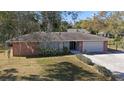 Charming single-story brick home featuring an attached garage and well-maintained lawn at 5150 Old Howell Branch Rd, Winter Park, FL 32792