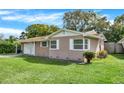 View of the home's exterior with a lush lawn and attached garage at 5715 Satel Dr, Orlando, FL 32810