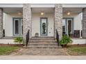 Inviting front porch with stone pillars, ceiling fans, and an elegant entrance at 8852 Sperry St, Orlando, FL 32827