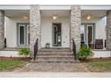 Inviting front porch featuring stone pillars, tiled stairs, and an elegant entrance at 8852 Sperry St, Orlando, FL 32827