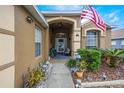 Inviting front porch with decorative plants and an American flag at 130 Bloomingdale Dr, Davenport, FL 33897