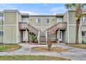 The exterior of the townhome features matching stairways, light green siding, and a front yard at 185 Scottsdale Sq # 185, Winter Park, FL 32792