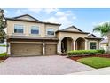 Elegant two-story home boasting a well-maintained lawn, brick driveway, and a welcoming front entrance at 2829 Autumn Breeze Way, Kissimmee, FL 34744