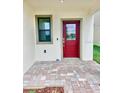 Inviting front porch with a red door and neutral-toned brick pavers at 3171 Cup Dr, Lakeland, FL 33803
