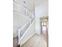 Bright hallway with neutral walls, white banisters, and large gray floor tiles at 3171 Cup Dr, Lakeland, FL 33803