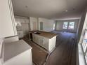 Open concept kitchen with white cabinets and a large island connecting to living room at 3171 Cup Dr, Lakeland, FL 33803