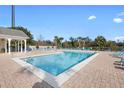 Community pool with lounge chairs and a covered pavilion on a sunny day, offering a relaxing atmosphere at 3176 Feltrim Pl # 205, Kissimmee, FL 34747