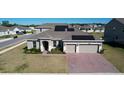 Charming home with solar panels, a brick driveway, and a manicured lawn at 4897 Gilded Jewel Dr, Mount Dora, FL 32757
