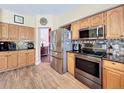 Bright kitchen with stainless steel appliances, tile backsplash, and wood-look flooring at 777 Crepe Myrtle Cir, Apopka, FL 32712